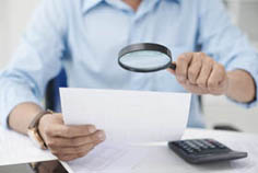 conseiller syndical scrutant un document à la loupe